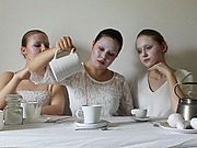 Foto von drei Schülerinnen in Weiß beim Tee Trinken
